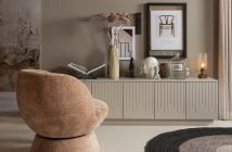 Polstersessel im Wohnzimmer mit einembeigefarbenen Sideboard