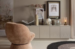 Polstersessel im Wohnzimmer mit einembeigefarbenen Sideboard