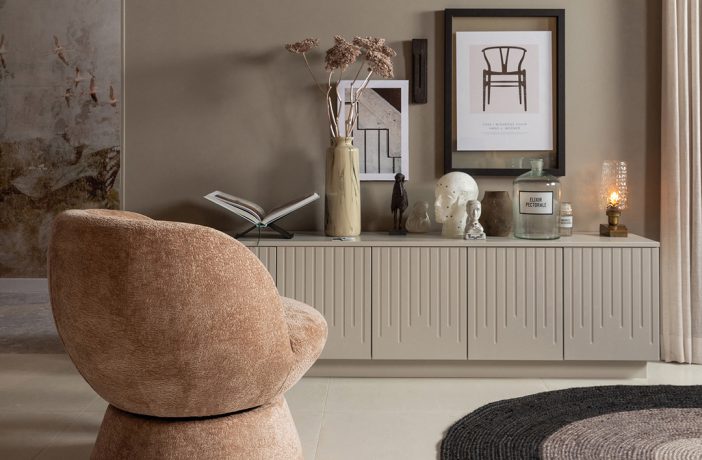 Polstersessel im Wohnzimmer mit einembeigefarbenen Sideboard