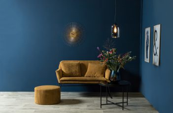 Wand in Petrol und ockerfarbene Möbel, passend zum Warm Nordic Living-Trend