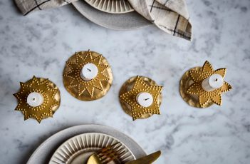 Tischdeko an Weihnachten mit goldenen Kerzenhaltern